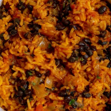 Plate of black beans and rice garnished with herbs and spices