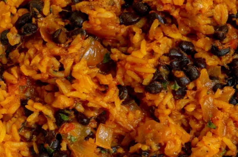 Plate of black beans and rice garnished with herbs and spices
