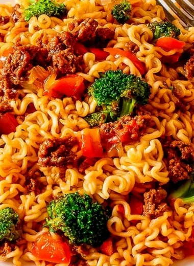 Cozy beef ramen noodles stir fry garnished with fresh vegetables and herbs