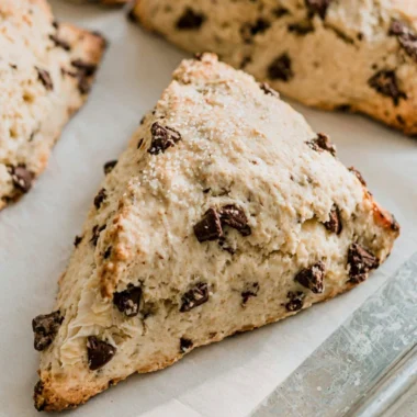Freshly baked chocolate chip sourdough scones on a wooden table