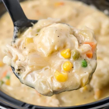 Bowl of cozy Crock Pot chicken and dumplings garnished with herbs