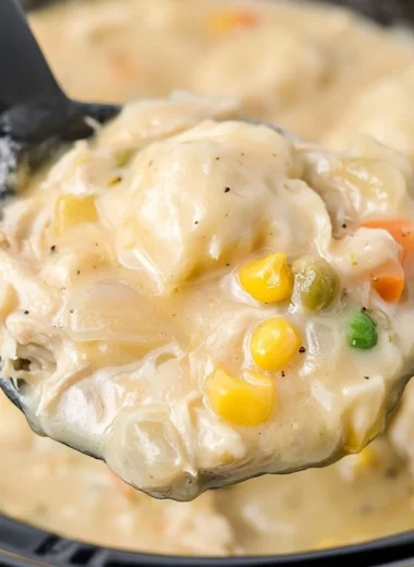 Bowl of cozy Crock Pot chicken and dumplings garnished with herbs