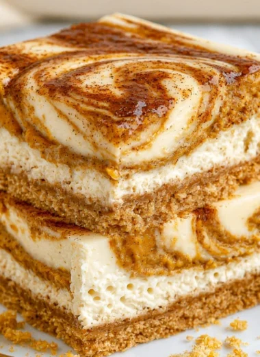 Cozy pumpkin cheesecake bars topped with whipped cream and autumn spices