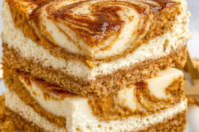 Cozy pumpkin cheesecake bars topped with whipped cream and autumn spices