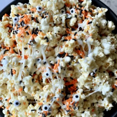 Colorful Halloween popcorn in a bowl with spooky decorations