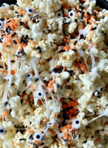 Colorful Halloween popcorn in a bowl with spooky decorations
