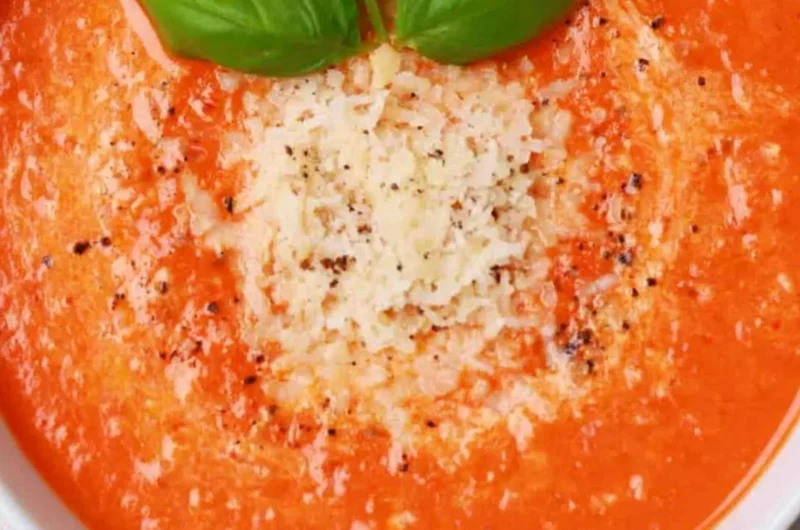 Bowl of high protein tomato soup garnished with fresh herbs