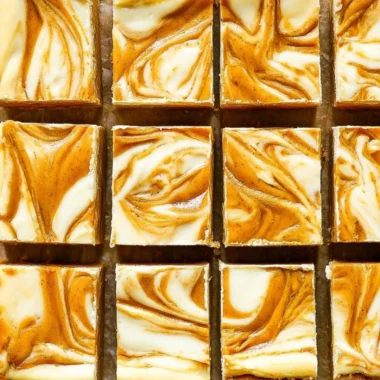Delicious pumpkin cheesecake bars topped with cream cheese frosting.