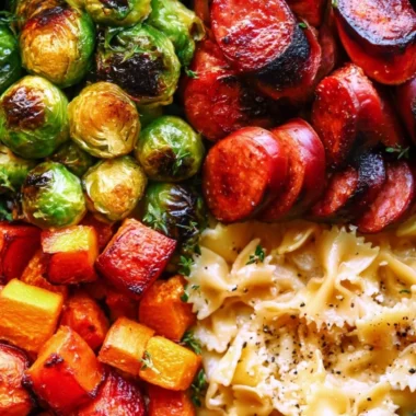 Autumn dinner featuring sausage, pasta, Brussels sprouts, and butternut squash on a rustic table.