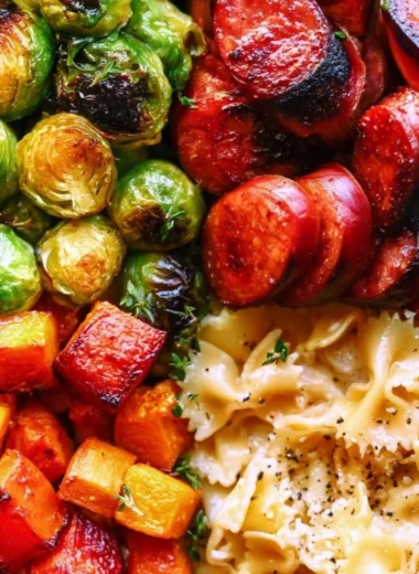 Autumn dinner featuring sausage, pasta, Brussels sprouts, and butternut squash on a rustic table.