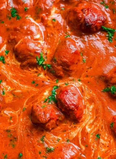 A bowl of cozy Chicken Tikka Masala with rice and fresh herbs