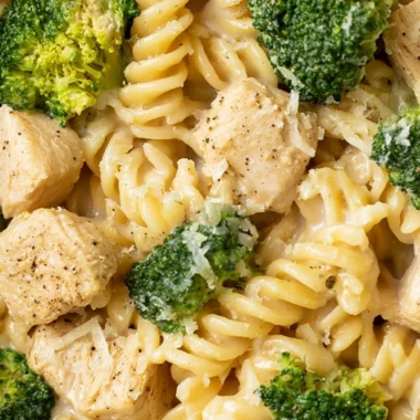 A delicious bowl of chicken broccoli pasta garnished with herbs.