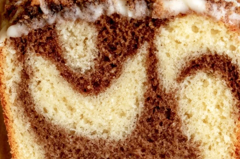 Cozy cinnamon loaf cake topped with a sprinkle of cinnamon.