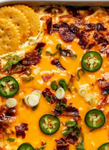 Creamy jalapeno popper dip served in a bowl with tortilla chips for dipping.