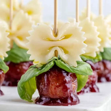 Bowtie pasta and cocktail meatball skewers on a serving platter