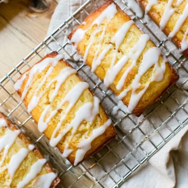 Slice of Eggnog Bread drizzled with Sugar Rum Glaze on a festive plate