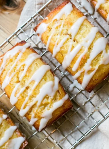 Slice of Eggnog Bread drizzled with Sugar Rum Glaze on a festive plate